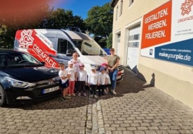 Gruppenfoto vorm Firmenfuhrpark