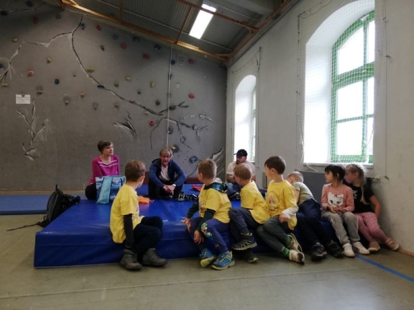 Sprachbegleiterin dolmetscht vor der Kletterwand