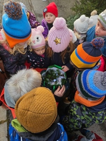 Neugierig schauen die Kinder in den Geschenkesack vom Weihnachtsmann.